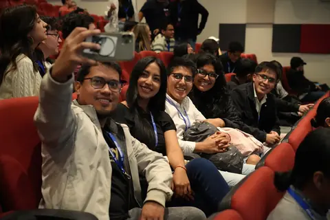 Asistentes se toman una selfie en el auditorio del AWS Community Day Ecuador 2025