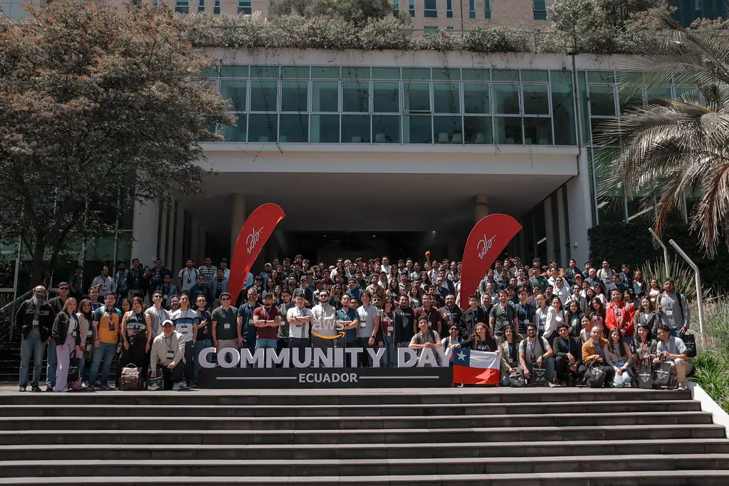 Cientos de asistentes del AWS Community Day Ecuador 2025 en las escaleras de la UDLA en Quito
