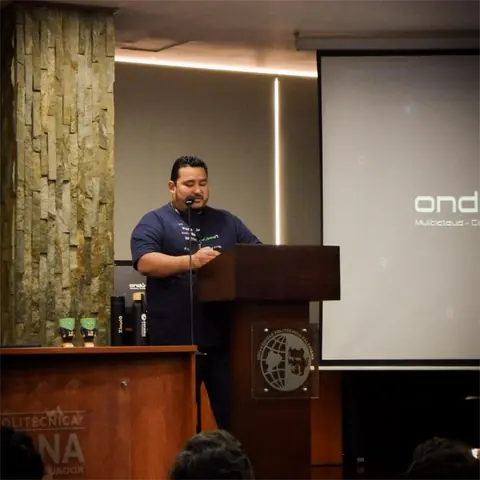 Alexis Polo, fundador de AWS User Group Ecuador, da la bienvenida desde el podio del AWS Security Day